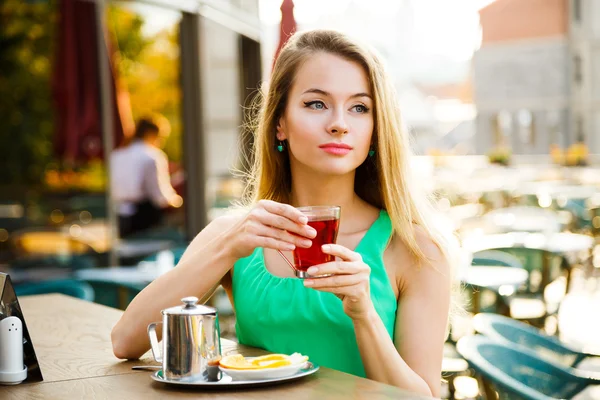 Vacker kvinna dricka te i en Cafe utomhus. — Stockfoto