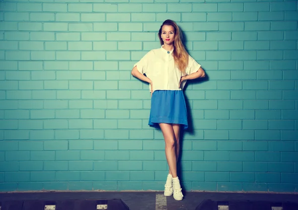 Μοντέρνα Hipster κορίτσι στον τοίχο τούβλου τυρκουάζ — Φωτογραφία Αρχείου
