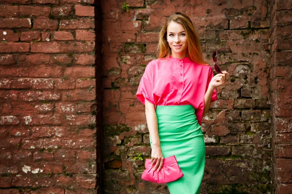 Happy Fashion vrouw aan de bakstenen muur — Stockfoto