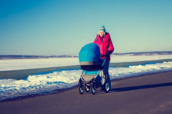 Poussette mère avec bébé Promenade dans le parc d'hiver — Photo