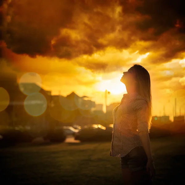 Silhouette einer jungen Frau bei urbanem Sonnenuntergang — Stockfoto