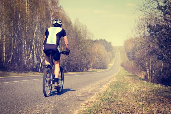 Sportowy człowiek jazda na rowerze na drodze — Zdjęcie stockowe