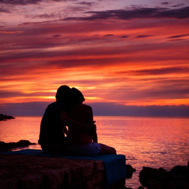 Romantik Çift deniz gün batımını izlemek silüeti