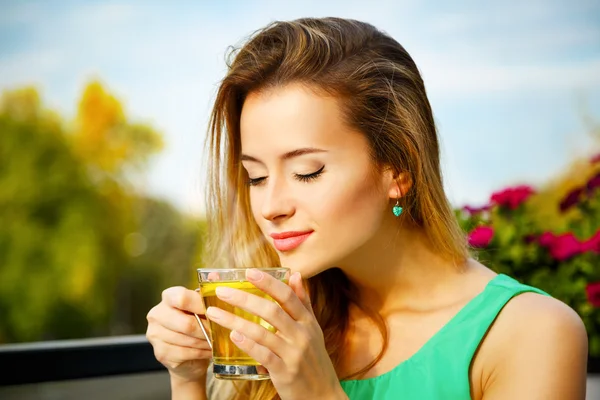 Mujer joven bebiendo té verde al aire libre — Foto de Stock