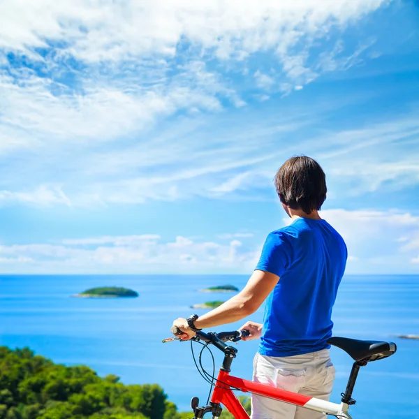 Homem com uma bicicleta no fundo da bela natureza — Fotografia de Stock