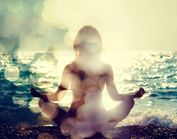 Deniz kenarında yoga yapan kadın.