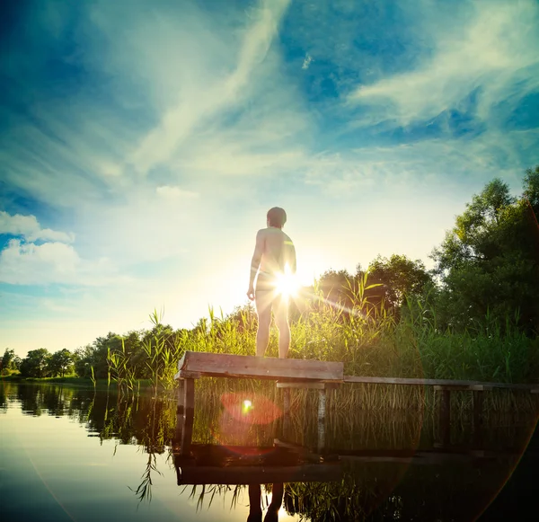 Junger Mann steht auf der Seebrücke am See — Stockfoto