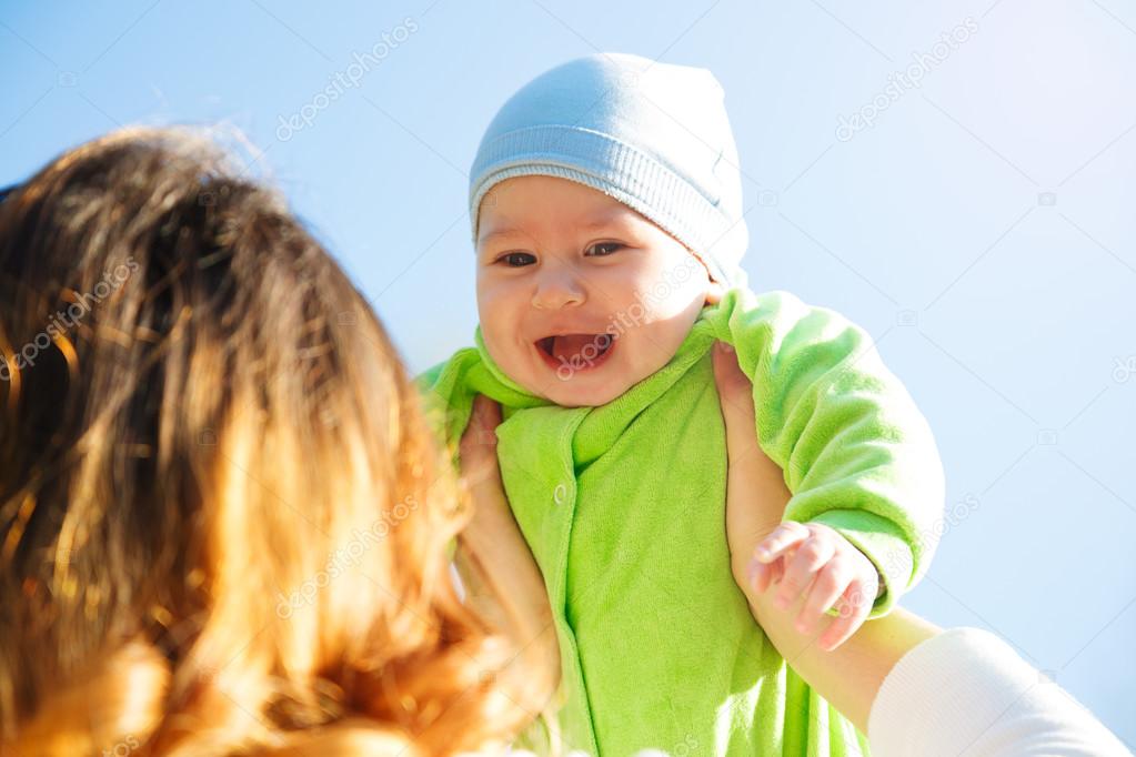 Mother Playing with Her Smiling Baby in Hands