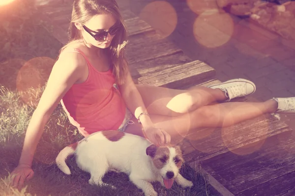Hipster dospívající dívka s její pes ležící na trávě. — Stock fotografie