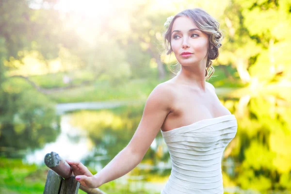 Stylische junge Braut im Freien vor grünem Naturhintergrund. getöntes Foto. — Stockfoto