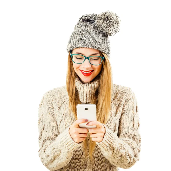 Usmívající se dívka zimní bederní pomocí mobilního telefonu na bílém pozadí — Stock fotografie