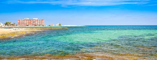 Spiaggia soleggiata del Mediterraneo, I turisti si rilassano sulla sabbia — Foto Stock