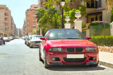 Kırmızı modern coupe araba Bmw M3 serisi güneşli bir sokakta, Torrevieja, 
