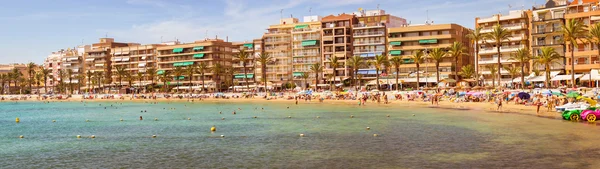 Playa mediterránea soleada, Los turistas se relajan en la arena, La gente se baña — Foto de Stock