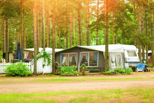 Camping vans and tents in wooded campsite. Hamina, Finland, Suomi