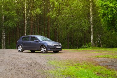 Koyu mavi Opel Astra H yeşil çayır üzerinde. Palvaanjarven kamp