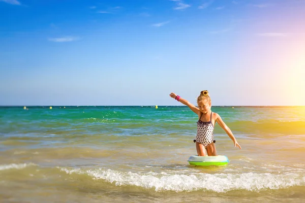 Roztomilá dívka v plavkách se koupe na vlny v moři. Sunny Mediterranea — Stock fotografie