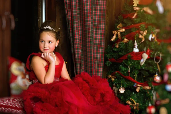 Pequena princesa de Natal, menina olha pela janela — Fotografia de Stock