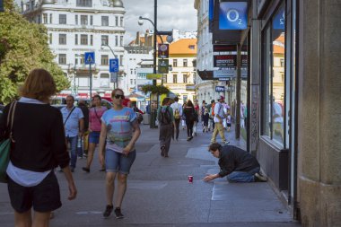 Evsiz bir dilenci yoğun bir cadde üzerinde yalvarıyor