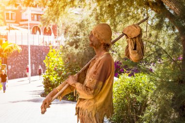 TENERIFE, SPAIN - JANUARY 14, 2013: Street performer-meme depicts a wandering poor man, Plaza Playa del Duque, Costa Adeje, Tenerife, Canary Islands, Spain clipart