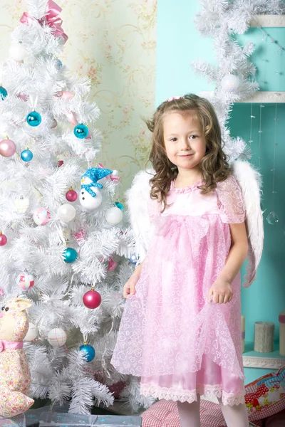 Esperando pelo Natal: uma menina se veste na árvore de Natal — Fotografia de Stock