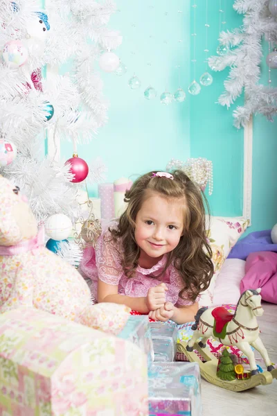 Esperando pelo Natal: uma menina se veste na árvore de Natal — Fotografia de Stock