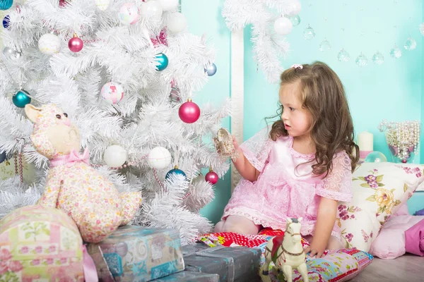 Esperando pelo Natal: uma menina se veste na árvore de Natal — Fotografia de Stock