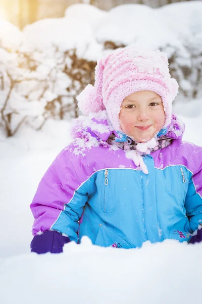 Glad liten flicka spelar med snö i Park — Stockfoto