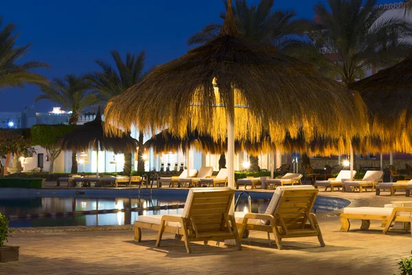 Sombrillas de paja y tumbonas junto a la piscina en Sharm El Sheikh — Foto de Stock