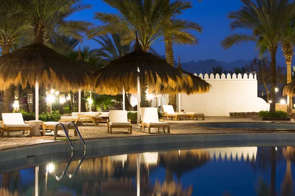 Sombrillas de paja y tumbonas junto a la piscina en Sharm El Sheikh — Foto de Stock