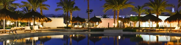 Sombrillas de paja y tumbonas junto a la piscina en Sharm El Sheikh — Foto de Stock