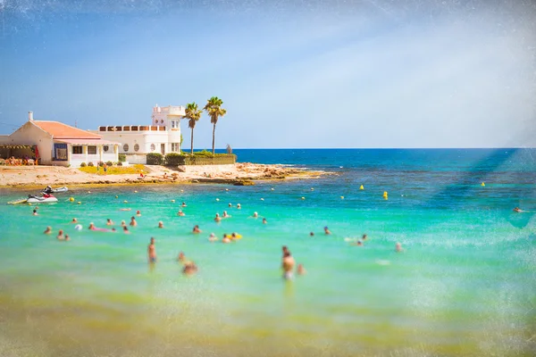 Primeiro plano desfocado. Praia ensolarada do Mediterrâneo, os turistas relaxam na onda — Fotografia de Stock