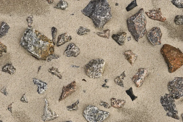 Granieten stenen op het zand. — Stockfoto