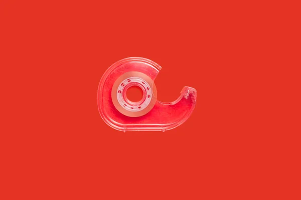 Dispensador de cinta adhesiva rosa aislado sobre fondo rojo —  Fotos de Stock