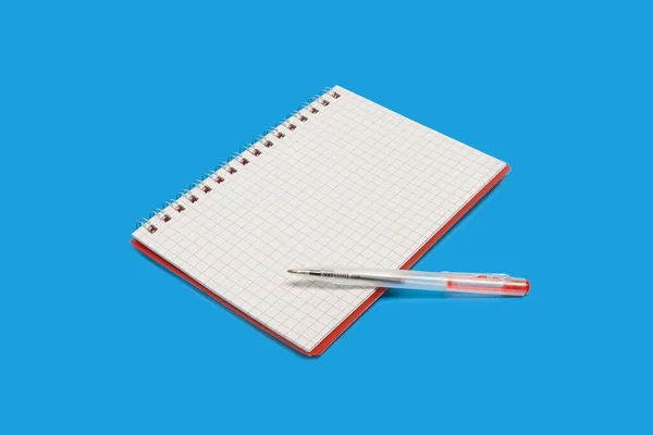 Spiraal notitieboekje met een pen op een blauwe achtergrond — Stockfoto