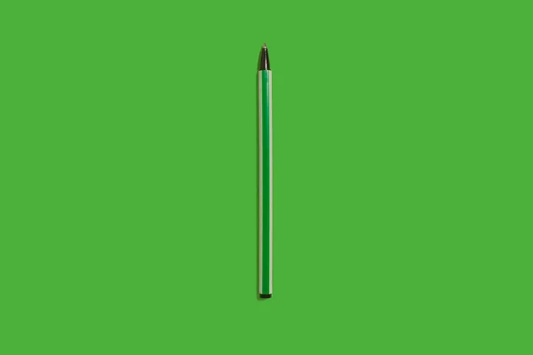 Πράσινο πλαστικό στυλό σε πράσινο πίσω. Αξεσουάρ γραφείων — Φωτογραφία Αρχείου