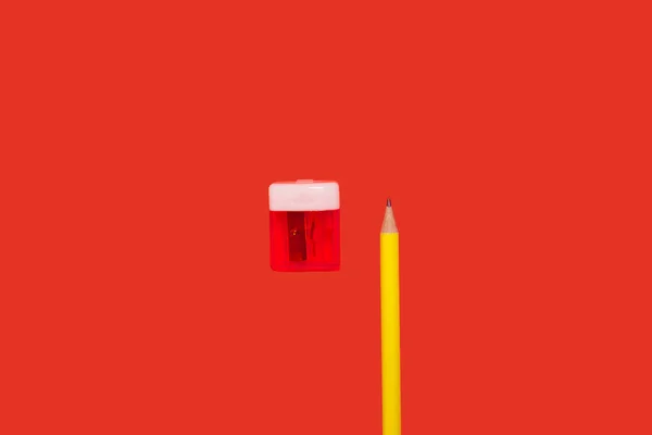 Um lápis amarelo e um afiador vermelho — Fotografia de Stock