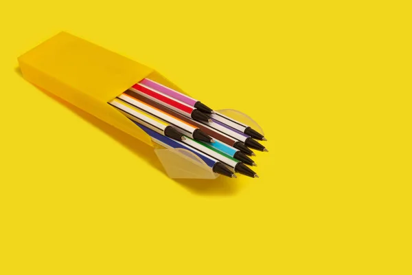 Colored pens in a yellow box. office accessories. school — стоковое фото