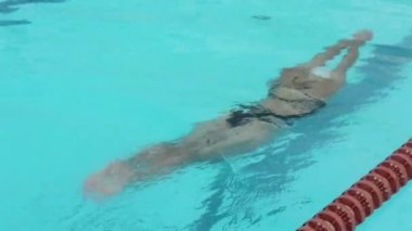 Yüzme. Kız havuzda yavaşça suyun altında kayıyor. Su sporları.