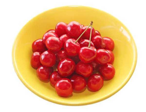 Ripe juicy cherries in a yellow plate on a white background — Stock Photo, Image