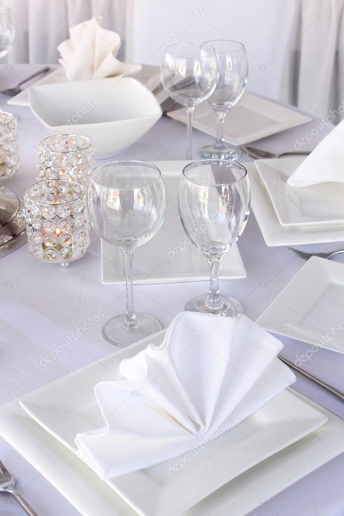 Table served with white square plates and wineglasses