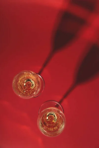 Des verres élégants de champagne sur fond rouge. Vue du dessus — Photo