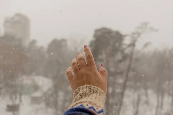 3.在下雪时，女人的手伸向雪花 — 图库照片