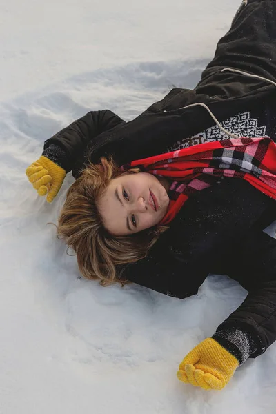 金发白人女孩躺在雪地上享受冬天 — 图库照片