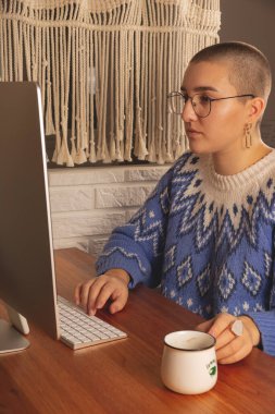 Kadın evde bilgisayarın başında çalışıyor. Salgın sırasında gerçek insanlar ve yeni bir gerçeklik.