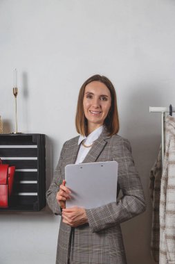 Kadın milenyum stilisti, tabletinin yanında giyinme odasındaki şık korkulukların üzerinde.. 