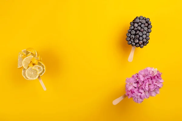 Kreativ glass gjord på blommor, blåbär och citron. Uppfriskande ljusa sommar dessert koncept — Stockfoto