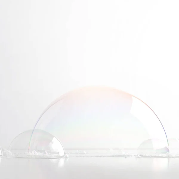 A hemisphere of a transparent soap bubble mockup for the presentation of cosmetics. White clean light background.