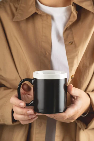 Taza de café negro maqueta para la demostración de diseño. Elegante taza de maqueta en manos femeninas. —  Fotos de Stock