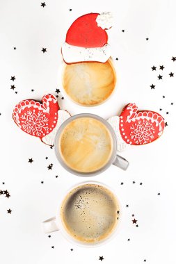 Zencefilli kurabiye, Noel Baba şapkası ve eldivenli kardan adam şeklinde üç fincan kahve..